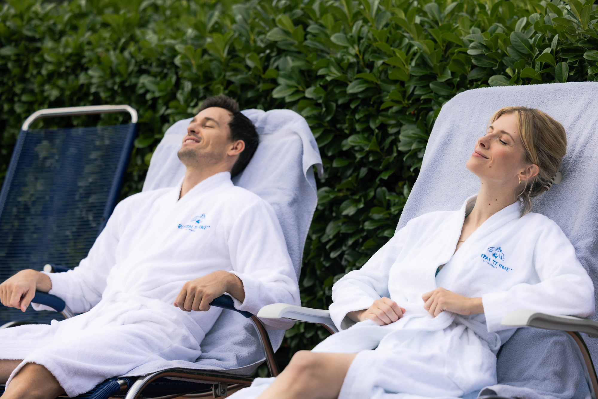 Zwei Personen entspannen im Bademantel auf den Liegen im Außenbereich der Rottal Terme